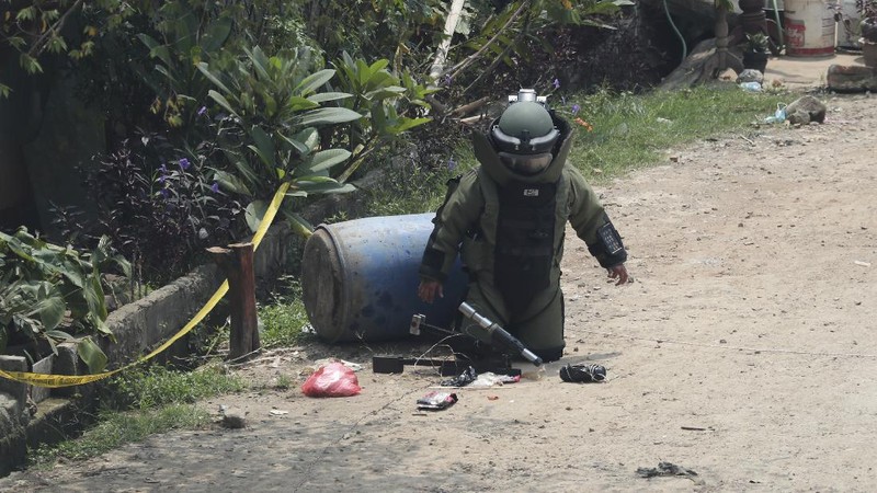 A member of the police bomb disposal squad leave s the scene after destroying a suspicious package found inside a garbage can in Bekasi on the outskirts of Jakarta, Indonesia, Monday, Aug. 23, 2021. Indonesia, the world's most populous Muslim nation, has carried out a sustained crackdown on Islamic militants since bombings on the tourist island of Bali in 2002 killed 202 people, mostly foreigners. Recently, attacks on foreign interests have been largely replaced in recent years by smaller, less deadly strikes targeting the government, mainly police and anti-terrorism forces. (AP Photo/Achmad Ibrahim)