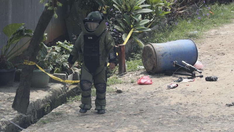 A member of the police bomb disposal squad leave s the scene after destroying a suspicious package found inside a garbage can in Bekasi on the outskirts of Jakarta, Indonesia, Monday, Aug. 23, 2021. Indonesia, the world's most populous Muslim nation, has carried out a sustained crackdown on Islamic militants since bombings on the tourist island of Bali in 2002 killed 202 people, mostly foreigners. Recently, attacks on foreign interests have been largely replaced in recent years by smaller, less deadly strikes targeting the government, mainly police and anti-terrorism forces. (AP Photo/Achmad Ibrahim)