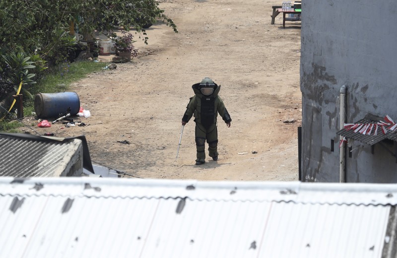 A member of the police bomb disposal squad leave s the scene after destroying a suspicious package found inside a garbage can in Bekasi on the outskirts of Jakarta, Indonesia, Monday, Aug. 23, 2021. Indonesia, the world's most populous Muslim nation, has carried out a sustained crackdown on Islamic militants since bombings on the tourist island of Bali in 2002 killed 202 people, mostly foreigners. Recently, attacks on foreign interests have been largely replaced in recent years by smaller, less deadly strikes targeting the government, mainly police and anti-terrorism forces. (AP Photo/Achmad Ibrahim)