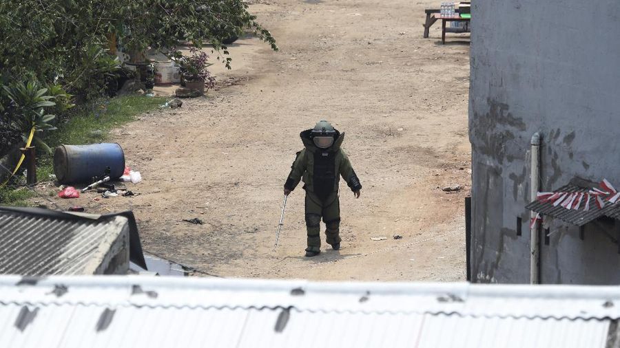A member of the police bomb disposal squad leave s the scene after destroying a suspicious package found inside a garbage can in Bekasi on the outskirts of Jakarta, Indonesia, Monday, Aug. 23, 2021. Indonesia, the world's most populous Muslim nation, has carried out a sustained crackdown on Islamic militants since bombings on the tourist island of Bali in 2002 killed 202 people, mostly foreigners. Recently, attacks on foreign interests have been largely replaced in recent years by smaller, less deadly strikes targeting the government, mainly police and anti-terrorism forces. (AP Photo/Achmad Ibrahim)