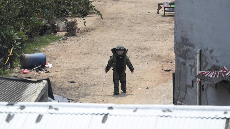 A member of the police bomb disposal squad leave s the scene after destroying a suspicious package found inside a garbage can in Bekasi on the outskirts of Jakarta, Indonesia, Monday, Aug. 23, 2021. Indonesia, the world's most populous Muslim nation, has carried out a sustained crackdown on Islamic militants since bombings on the tourist island of Bali in 2002 killed 202 people, mostly foreigners. Recently, attacks on foreign interests have been largely replaced in recent years by smaller, less deadly strikes targeting the government, mainly police and anti-terrorism forces. (AP Photo/Achmad Ibrahim)