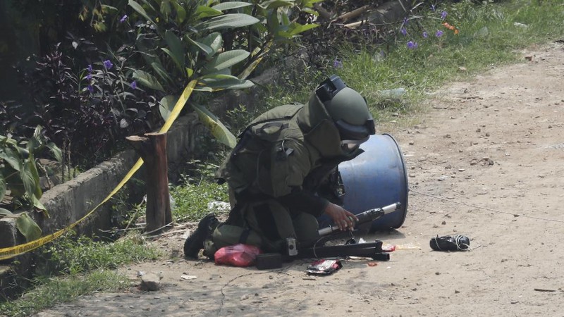 A member of the police bomb disposal squad leave s the scene after destroying a suspicious package found inside a garbage can in Bekasi on the outskirts of Jakarta, Indonesia, Monday, Aug. 23, 2021. Indonesia, the world's most populous Muslim nation, has carried out a sustained crackdown on Islamic militants since bombings on the tourist island of Bali in 2002 killed 202 people, mostly foreigners. Recently, attacks on foreign interests have been largely replaced in recent years by smaller, less deadly strikes targeting the government, mainly police and anti-terrorism forces. (AP Photo/Achmad Ibrahim)