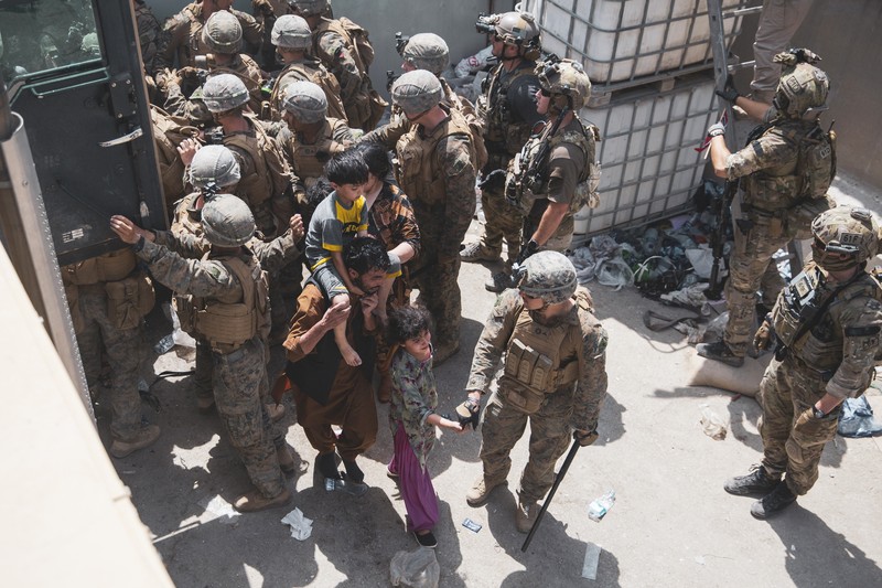 US Afghanistan In this Aug. 20, 2021, photo provided by the U.S. Marine Corps, U.S. Marines and Norweigian coalition forces assist with security at an Evacuation Control Checkpoint ensuring evacuees are processed safely during an evacuation at Hamid Karzai International Airport in Kabul, Afghanistan. (Staff Sgt. Victor Mancilla/U.S. Marine Corps via AP)