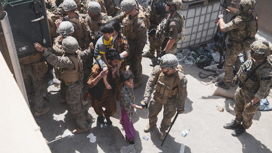 In this Aug. 20, 2021, photo provided by the U.S. Marine Corps, U.S. Marines and Norweigian coalition forces assist with security at an Evacuation Control Checkpoint ensuring evacuees are processed safely during an evacuation at Hamid Karzai International Airport in Kabul, Afghanistan. (Staff Sgt. Victor Mancilla/U.S. Marine Corps via AP)