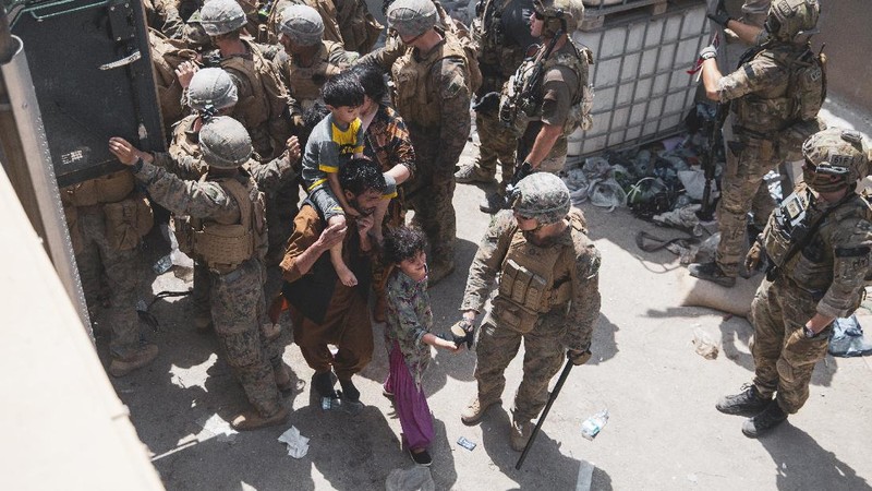 In this Aug. 20, 2021, photo provided by the U.S. Marine Corps, U.S. Marines and Norweigian coalition forces assist with security at an Evacuation Control Checkpoint ensuring evacuees are processed safely during an evacuation at Hamid Karzai International Airport in Kabul, Afghanistan. (Staff Sgt. Victor Mancilla/U.S. Marine Corps via AP)