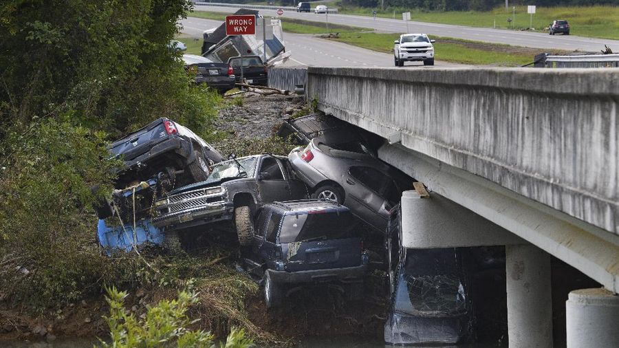 Cars are stacked on top of each other on the banks of Blue Creek being swept up in flood water, Monday, Aug. 23, 2021, in Waverly, Tenn. Heavy rains caused flooding in Middle Tennessee days ago and have resulted in multiple deaths as homes and rural roads were washed away. (AP Photo/John Amis)