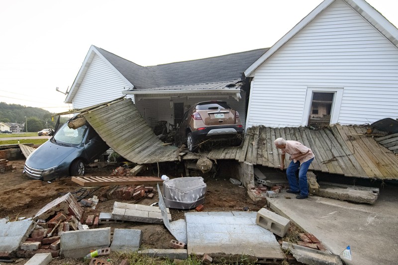 Cars are stacked on top of each other on the banks of Blue Creek being swept up in flood water, Monday, Aug. 23, 2021, in Waverly, Tenn. Heavy rains caused flooding in Middle Tennessee days ago and have resulted in multiple deaths as homes and rural roads were washed away. (AP Photo/John Amis)