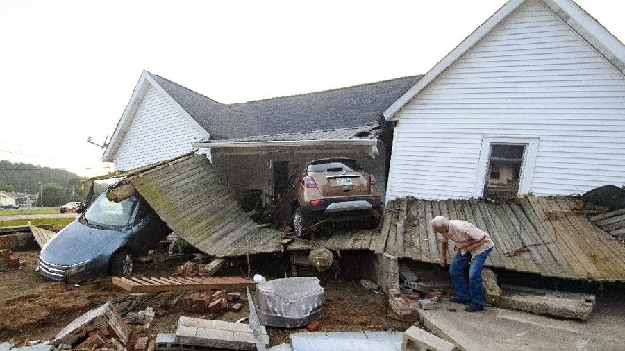 Cars are stacked on top of each other on the banks of Blue Creek being swept up in flood water, Monday, Aug. 23, 2021, in Waverly, Tenn. Heavy rains caused flooding in Middle Tennessee days ago and have resulted in multiple deaths as homes and rural roads were washed away. (AP Photo/John Amis)