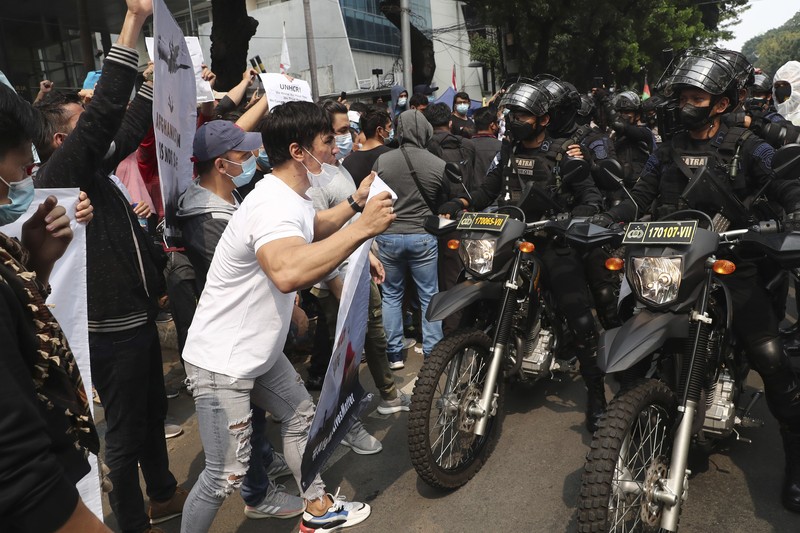 Afghan refugees  living in Indonesia shout slogans during a rally outside the building that houses UNHCR representative office in Jakarta, Indonesia, Tuesday, Aug. 24, 2021. The protesters, mostly members of the Hazara ethnic minority, held the rally on Tuesday decrying the Taliban's takeover of their country and calling for resettlement in third countries. (AP Photo/Tatan Syuflana)