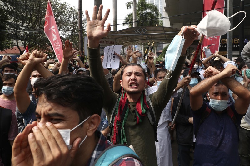 Afghan refugees  living in Indonesia shout slogans during a rally outside the building that houses UNHCR representative office in Jakarta, Indonesia, Tuesday, Aug. 24, 2021. The protesters, mostly members of the Hazara ethnic minority, held the rally on Tuesday decrying the Taliban's takeover of their country and calling for resettlement in third countries. (AP Photo/Tatan Syuflana)