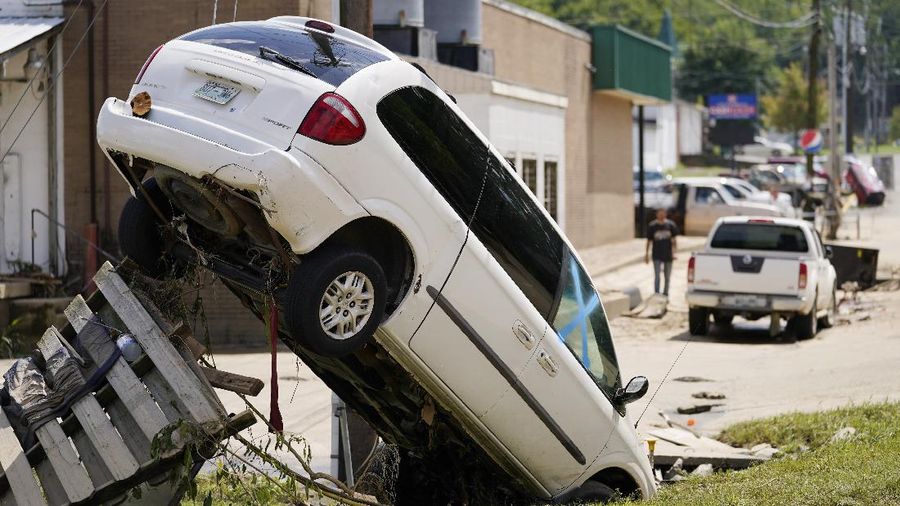 Cars are stacked on top of each other on the banks of Blue Creek being swept up in flood water, Monday, Aug. 23, 2021, in Waverly, Tenn. Heavy rains caused flooding in Middle Tennessee days ago and have resulted in multiple deaths as homes and rural roads were washed away. (AP Photo/John Amis)