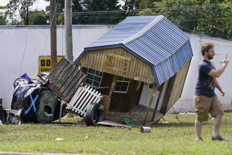 Cars are stacked on top of each other on the banks of Blue Creek being swept up in flood water, Monday, Aug. 23, 2021, in Waverly, Tenn. Heavy rains caused flooding in Middle Tennessee days ago and have resulted in multiple deaths as homes and rural roads were washed away. (AP Photo/John Amis)