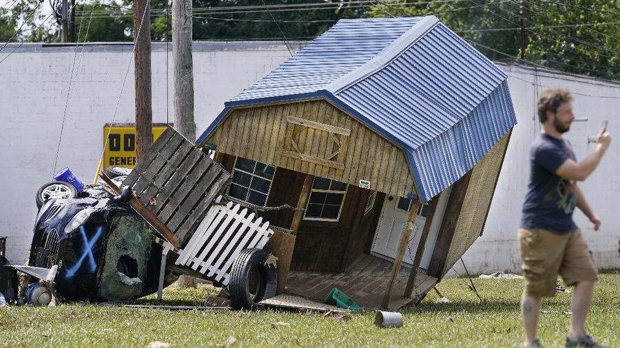 Cars are stacked on top of each other on the banks of Blue Creek being swept up in flood water, Monday, Aug. 23, 2021, in Waverly, Tenn. Heavy rains caused flooding in Middle Tennessee days ago and have resulted in multiple deaths as homes and rural roads were washed away. (AP Photo/John Amis)