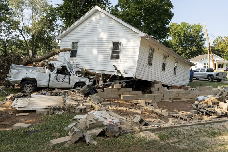 Cars are stacked on top of each other on the banks of Blue Creek being swept up in flood water, Monday, Aug. 23, 2021, in Waverly, Tenn. Heavy rains caused flooding in Middle Tennessee days ago and have resulted in multiple deaths as homes and rural roads were washed away. (AP Photo/John Amis)