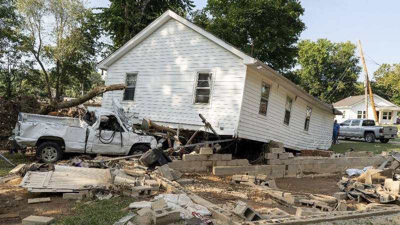 Cars are stacked on top of each other on the banks of Blue Creek being swept up in flood water, Monday, Aug. 23, 2021, in Waverly, Tenn. Heavy rains caused flooding in Middle Tennessee days ago and have resulted in multiple deaths as homes and rural roads were washed away. (AP Photo/John Amis)
