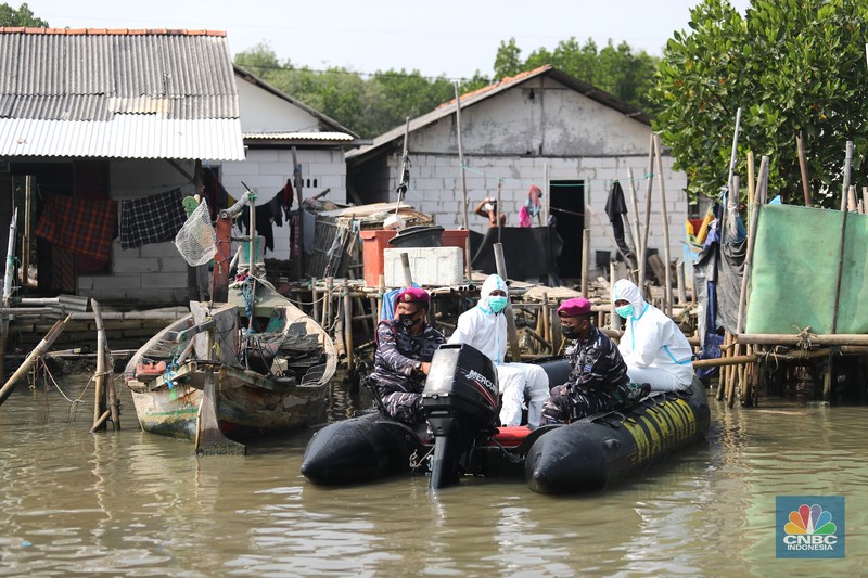 Prajurit TNI AL melaksanakan operasi kemanusiaan serbuan vaksin massal di Wilayah Muara Gembong, Jawa Barat. Program vaksinasi ini menyasar kepada 1.000 warga didaerah pesisir pantai tersebut. (CNBC Indonesia/Tri Susilo)