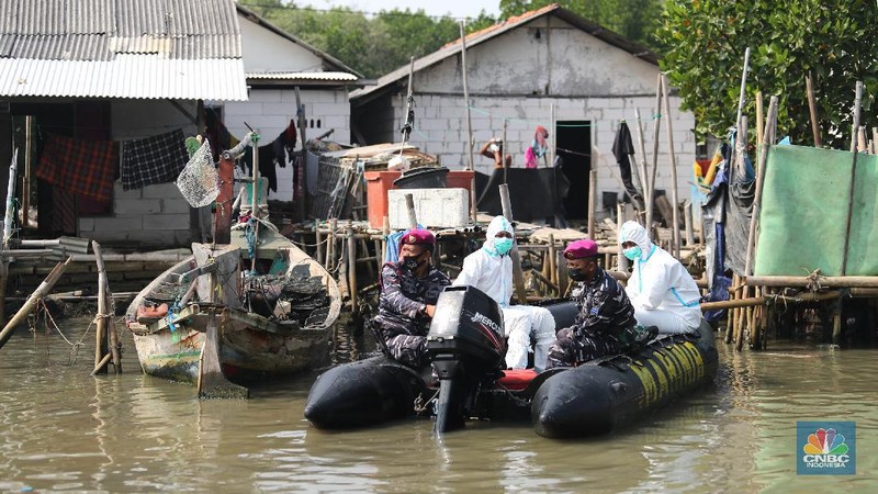 Prajurit TNI AL melaksanakan operasi kemanusiaan serbuan vaksin massal di Wilayah Muara Gembong, Jawa Barat. Program vaksinasi ini menyasar kepada 1.000 warga didaerah pesisir pantai tersebut. (CNBC Indonesia/Tri Susilo)