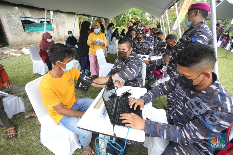 Prajurit TNI AL melaksanakan operasi kemanusiaan serbuan vaksin massal di Wilayah Muara Gembong, Jawa Barat. Program vaksinasi ini menyasar kepada 1.000 warga didaerah pesisir pantai tersebut. (CNBC Indonesia/Tri Susilo)