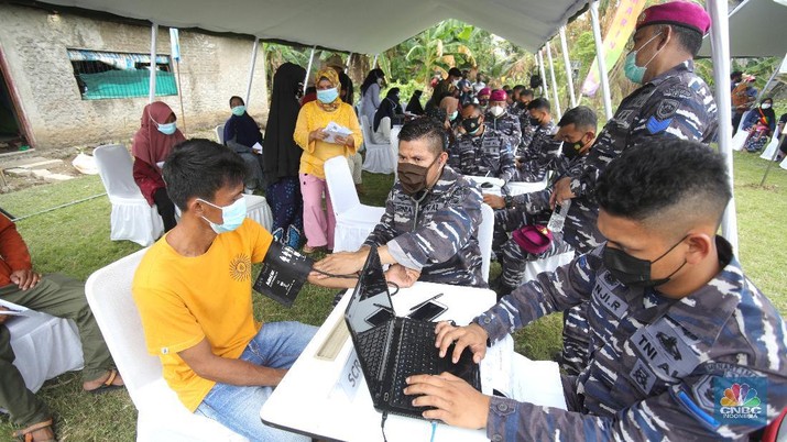 Prajurit TNI AL melaksanakan operasi kemanusiaan serbuan vaksin massal di Wilayah Muara Gembong, Jawa Barat. Program vaksinasi ini menyasar kepada 1.000 warga didaerah pesisir pantai tersebut. (CNBC Indonesia/Tri Susilo)