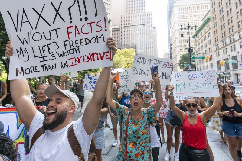 Virus Outbreak Vaccine Mandates Protesters hold their hands to their hearts during the national anthem at a demonstration against COVID-19 vaccination mandates, Wednesday, Aug. 25, 2021, in New York. (AP Photo/Mary Altaffer)