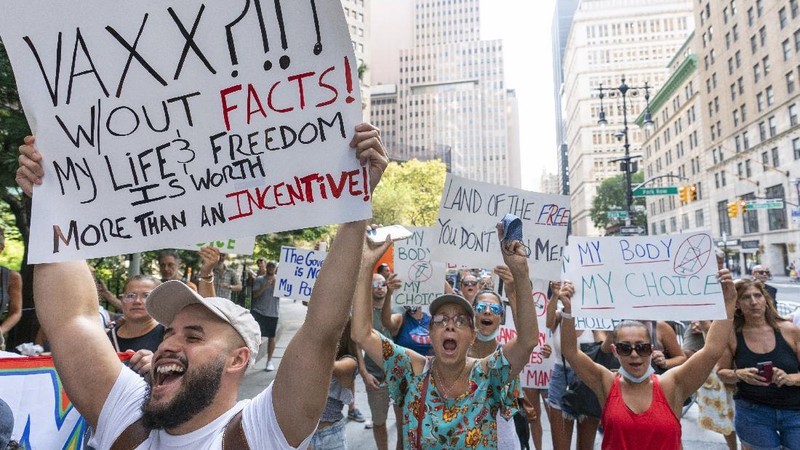 Protesters hold their hands to their hearts during the national anthem at a demonstration against COVID-19 vaccination mandates, Wednesday, Aug. 25, 2021, in New York. (AP Photo/Mary Altaffer)