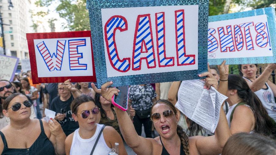 Protesters hold their hands to their hearts during the national anthem at a demonstration against COVID-19 vaccination mandates, Wednesday, Aug. 25, 2021, in New York. (AP Photo/Mary Altaffer)