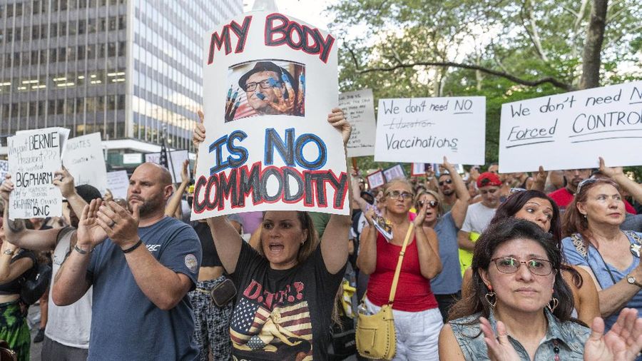 Protesters hold their hands to their hearts during the national anthem at a demonstration against COVID-19 vaccination mandates, Wednesday, Aug. 25, 2021, in New York. (AP Photo/Mary Altaffer)