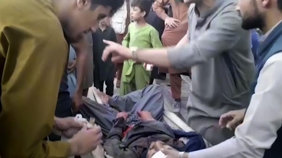 In this frame grab from video, people attend to a wounded man near the site of a deadly explosion outside the airport in Kabul, Afghanistan, Thursday, Aug. 26, 2021. Two suicide bombers and gunmen have targeted crowds massing near the Kabul airport, in the waning days of a massive airlift that has drawn thousands of people seeking to flee the Taliban takeover of Afghanistan. (AP Photo)