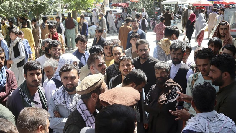 Afghans wait for hours to try to withdraw money, in front of Kabul Bank, in Kabul, Afghanistan, Saturday, Aug. 28, 2021. (AP Photo/Khwaja Tawfiq Sediqi)