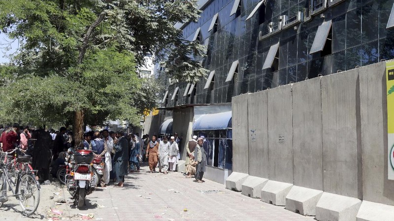 Afghans wait for hours to try to withdraw money, in front of Kabul Bank, in Kabul, Afghanistan, Saturday, Aug. 28, 2021. (AP Photo/Khwaja Tawfiq Sediqi)