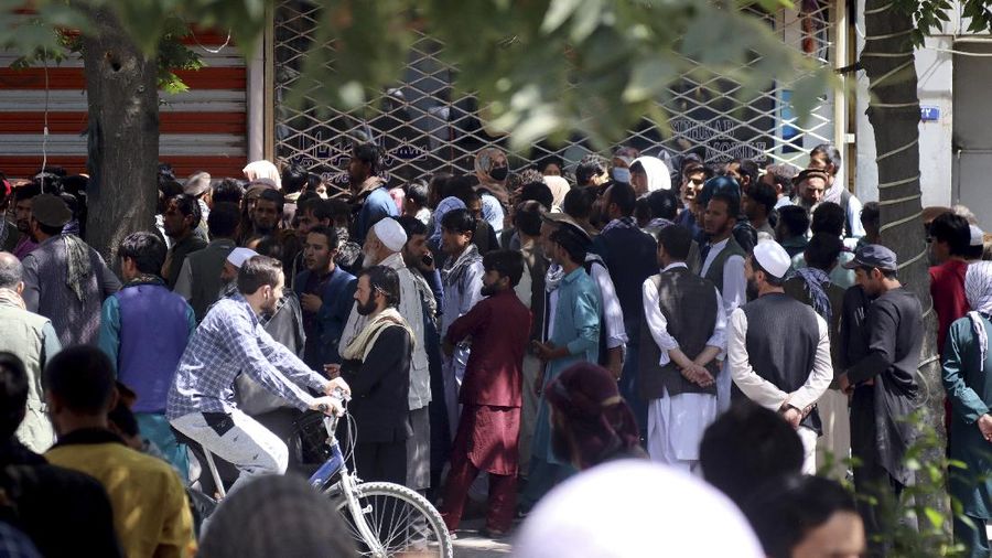 Afghans wait for hours to try to withdraw money, in front of Kabul Bank, in Kabul, Afghanistan, Saturday, Aug. 28, 2021. (AP Photo/Khwaja Tawfiq Sediqi)