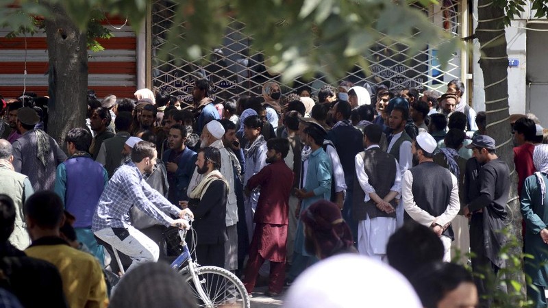 Afghans wait for hours to try to withdraw money, in front of Kabul Bank, in Kabul, Afghanistan, Saturday, Aug. 28, 2021. (AP Photo/Khwaja Tawfiq Sediqi)