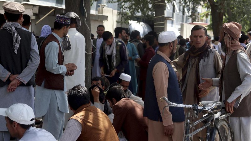 Afghans wait for hours to try to withdraw money, in front of Kabul Bank, in Kabul, Afghanistan, Saturday, Aug. 28, 2021. (AP Photo/Khwaja Tawfiq Sediqi)