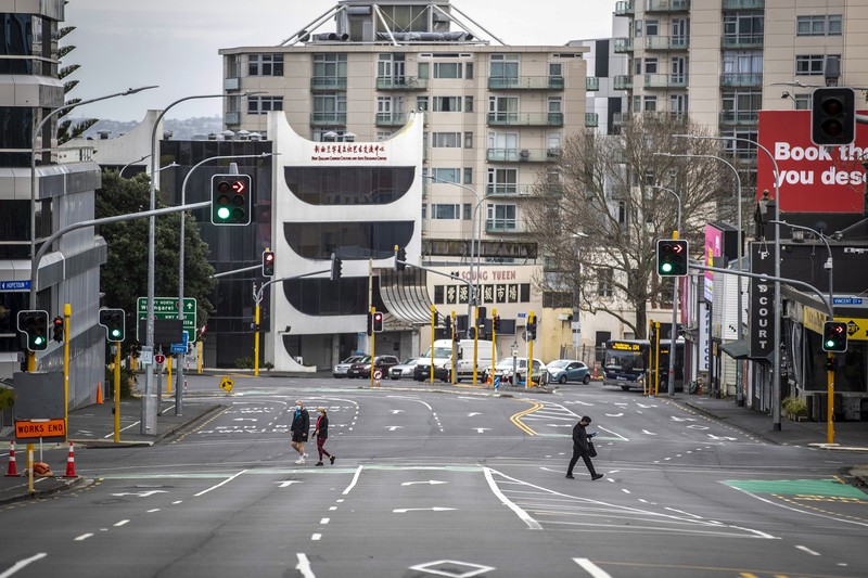 Virus Outbreak New Zealand People cross nearly empty streets in the central business district of Auckland, New Zealand, Friday Aug. 27, 2021. By early next week, New Zealanders should know if their government's strict new lockdown is working to stamp out its first coronavirus outbreak in six months. A successful effort could again make the nation's virus response the envy of the world. (Michael Craig/NZ Herald via AP)