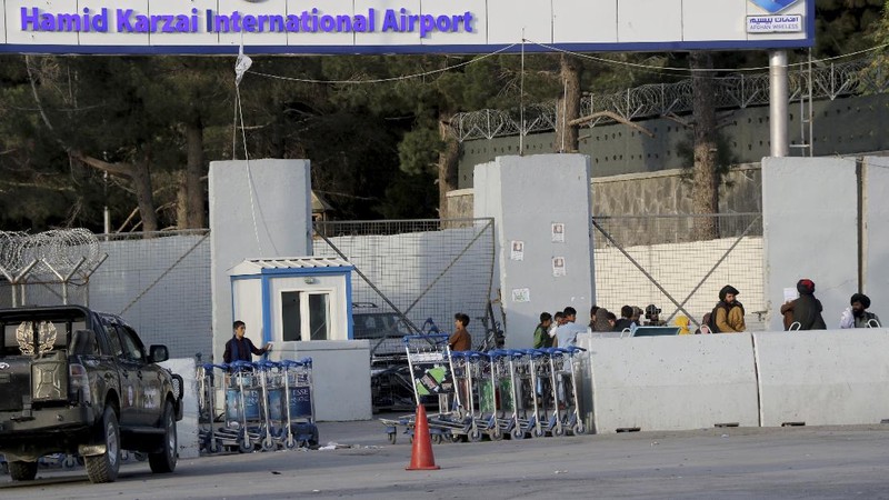 Taliban fighters stand guard at a checkpoint near the gate of Hamid Karzai international Airport in Kabul, Afghanistan, Saturday, Aug. 28, 2021.  The Taliban have sealed off Kabul’s airport to most would-be evacuees to prevent large crowds from gathering after this week's deadly suicide attack. The massive U.S.-led airlift was winding down Saturday ahead of a U.S. deadline to withdraw from Afghanistan by Tuesday. (AP Photo/Wali Sabawoon)