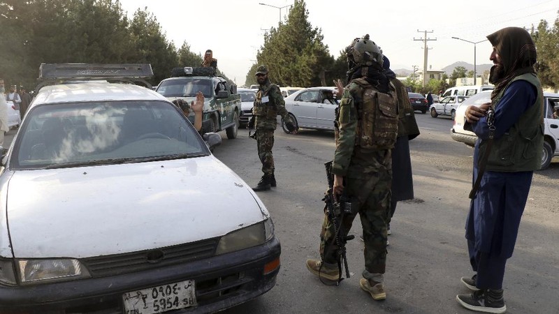Taliban fighters stand guard at a checkpoint near the gate of Hamid Karzai international Airport in Kabul, Afghanistan, Saturday, Aug. 28, 2021.  The Taliban have sealed off Kabul’s airport to most would-be evacuees to prevent large crowds from gathering after this week's deadly suicide attack. The massive U.S.-led airlift was winding down Saturday ahead of a U.S. deadline to withdraw from Afghanistan by Tuesday. (AP Photo/Wali Sabawoon)