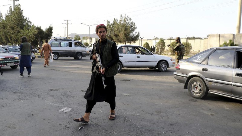 Taliban fighters stand guard at a checkpoint near the gate of Hamid Karzai international Airport in Kabul, Afghanistan, Saturday, Aug. 28, 2021.  The Taliban have sealed off Kabul’s airport to most would-be evacuees to prevent large crowds from gathering after this week's deadly suicide attack. The massive U.S.-led airlift was winding down Saturday ahead of a U.S. deadline to withdraw from Afghanistan by Tuesday. (AP Photo/Wali Sabawoon)
