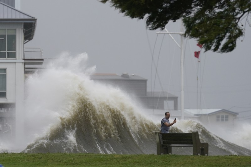 Badai Ida di AS A man passes by a section of roof that was blown off of a building in the French Quarter by Hurricane Ida winds, Sunday, Aug. 29, 2021, in New Orleans. (AP Photo/Eric Gay)