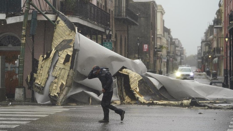 A man passes by a section of roof that was blown off of a building in the French Quarter by Hurricane Ida winds, Sunday, Aug. 29, 2021, in New Orleans. (AP Photo/Eric Gay)
