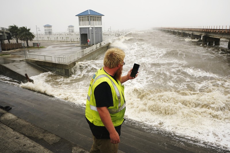 A man passes by a section of roof that was blown off of a building in the French Quarter by Hurricane Ida winds, Sunday, Aug. 29, 2021, in New Orleans. (AP Photo/Eric Gay)