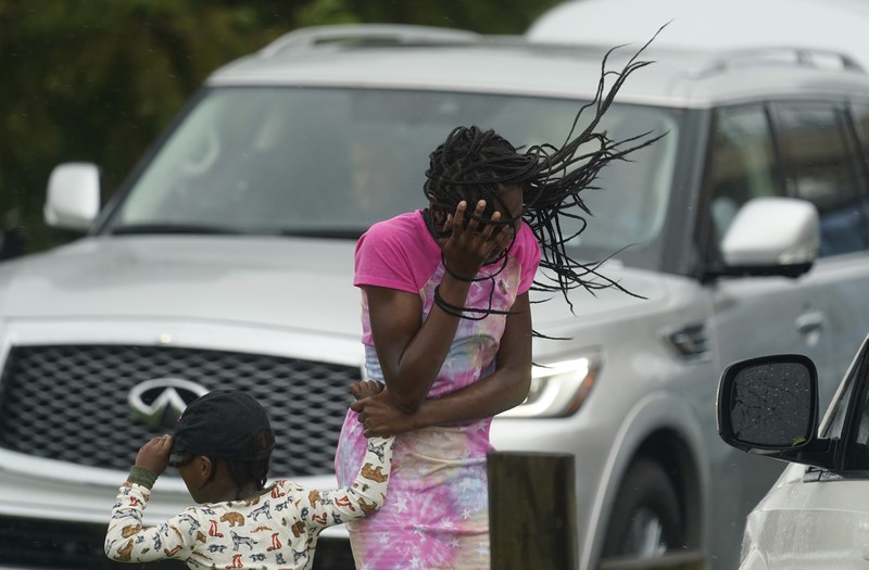 A man passes by a section of roof that was blown off of a building in the French Quarter by Hurricane Ida winds, Sunday, Aug. 29, 2021, in New Orleans. (AP Photo/Eric Gay)