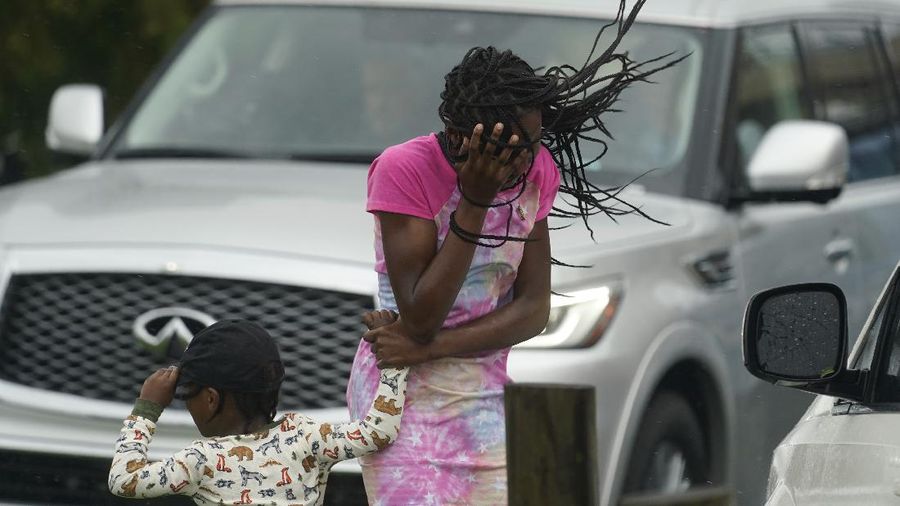 A man passes by a section of roof that was blown off of a building in the French Quarter by Hurricane Ida winds, Sunday, Aug. 29, 2021, in New Orleans. (AP Photo/Eric Gay)