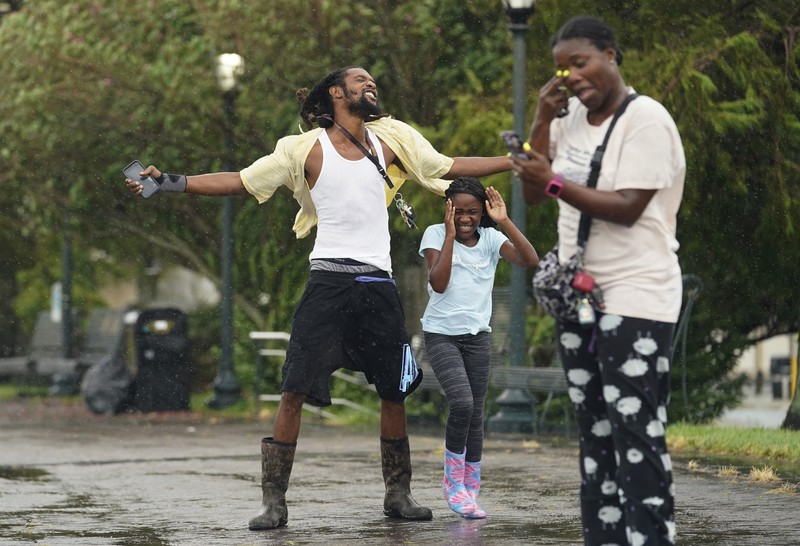 Badai Ida di AS A man passes by a section of roof that was blown off of a building in the French Quarter by Hurricane Ida winds, Sunday, Aug. 29, 2021, in New Orleans. (AP Photo/Eric Gay)