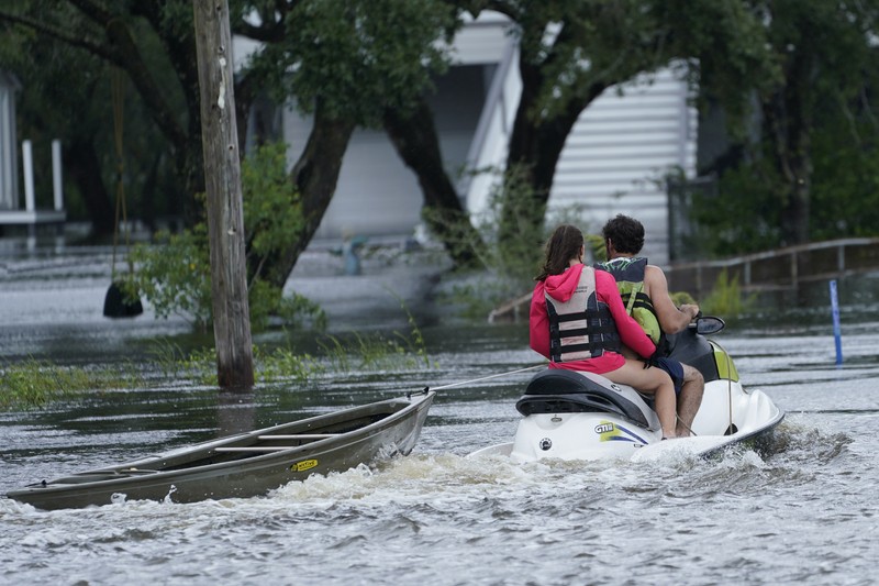 A man passes by a section of roof that was blown off of a building in the French Quarter by Hurricane Ida winds, Sunday, Aug. 29, 2021, in New Orleans. (AP Photo/Eric Gay)