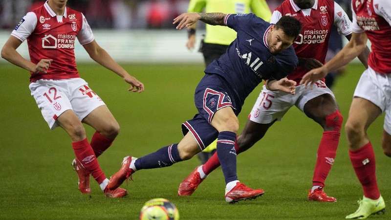 Reims' Marshall Munetsi, left, challenges for the ball with PSG's Lionel Messi during the France League One soccer match between Reims and Paris Saint-Germain, at the Stade Auguste-Delaune in Reims, France, Sunday, Aug. 29, 2021. (AP Photo/Francois Mori)