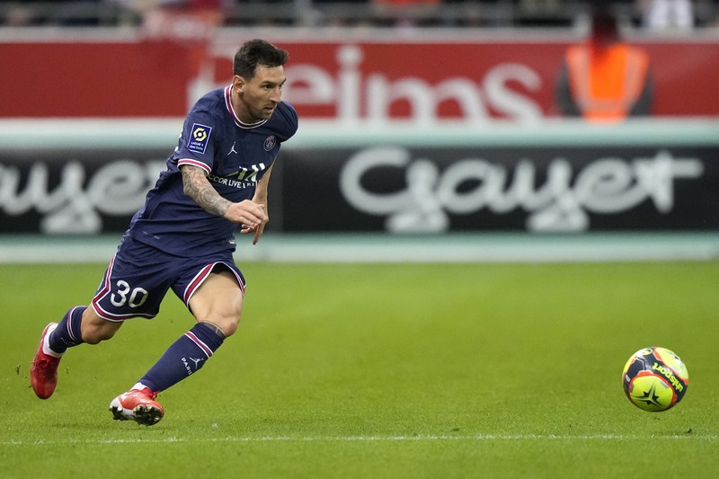 France Soccer League One Reims' Marshall Munetsi, left, challenges for the ball with PSG's Lionel Messi during the France League One soccer match between Reims and Paris Saint-Germain, at the Stade Auguste-Delaune in Reims, France, Sunday, Aug. 29, 2021. (AP Photo/Francois Mori)