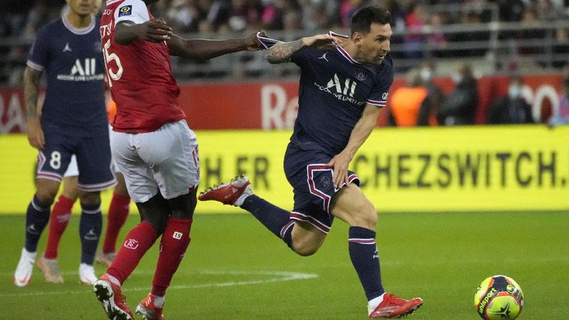 Reims' Marshall Munetsi, left, challenges for the ball with PSG's Lionel Messi during the France League One soccer match between Reims and Paris Saint-Germain, at the Stade Auguste-Delaune in Reims, France, Sunday, Aug. 29, 2021. (AP Photo/Francois Mori)