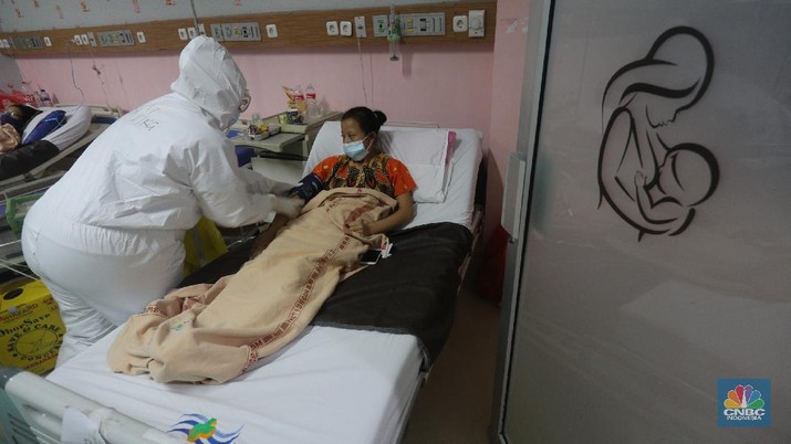 Pasien Covid-19 di RSUD Koja Petugas kesehatan memeriksa pasien Covid-19 diruangan Instalasi Gawat Darurat (IGD) di RSUD Koja, Jakarta, Senin (30/8/2021). Jumlah pasien Covid-19 yang dirawat di RSUD Koja terus menurun dengan peningkatan pasien sembuh.
Diruangan IGD hanya ada tiga pasien Covid-19 yang sedang ditangani lebih lanjut.
Di ruangan bayi terisi dua bayi berada didalam inkubator dengan penanganan khusus dari para nakes.
Berdasarkan data Kementerian Kesehatan (Kemenkes) kasus konfirmasi positif Covid-19 di tanah air hari ini bertambah 5.436 kasus, menurun dibandingkan dengan sehari sebelumnya 7.427 kasus.
Dengan pertambahan ini maka total kasus konfirmasi positif Covid-19 di Indonesia mencapai 4,079 juta.
Sementara, jumlah pasien sembuh bertambah 19.398 orang pada hari ini, sehingga total kasus sembuh menjadi 3.743.716. (CNBC Indonesia/ Tri Susilo)