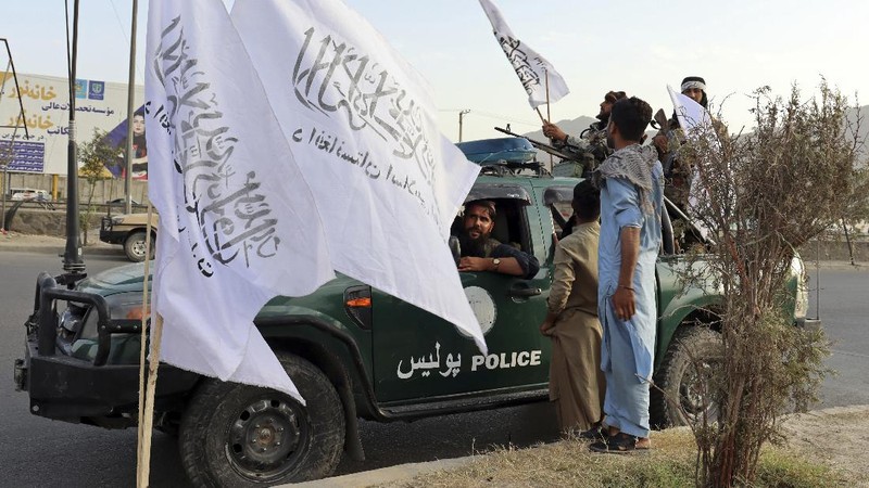 Taliban fighters hold Taliban flags in Kabul, Afghanistan, Monday, Aug. 30, 2021. Many Afghans are anxious about the Taliban rule and are figuring out ways to get out of Afghanistan. But it's the financial desperation that seems to hang heavy over the city. (AP Photo/Khwaja Tawfiq Sediqi)