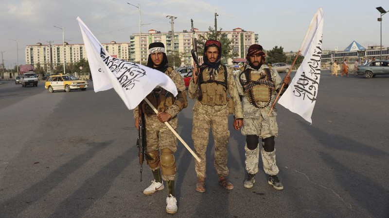Taliban fighters hold Taliban flags in Kabul, Afghanistan, Monday, Aug. 30, 2021. Many Afghans are anxious about the Taliban rule and are figuring out ways to get out of Afghanistan. But it's the financial desperation that seems to hang heavy over the city. (AP Photo/Khwaja Tawfiq Sediqi)
